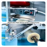 Registration mark sensor and film loading frame for bottom film flow wrapper