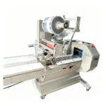 Top film horizontal flow wrapper film roll and feeding system