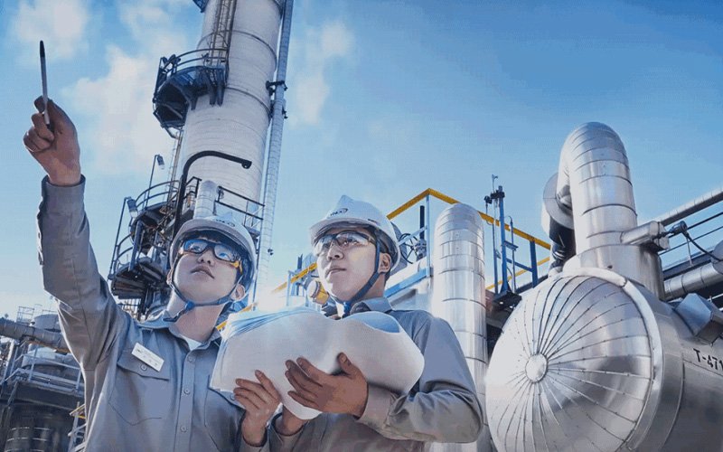 Chemical plant engineers inspect PTFE lined metal hose piping for corrosive media transmission