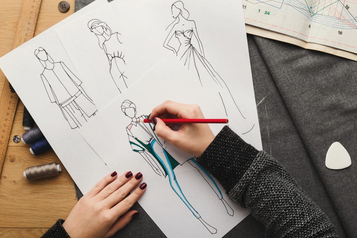 Top view on woman designer drawing clothes sketches